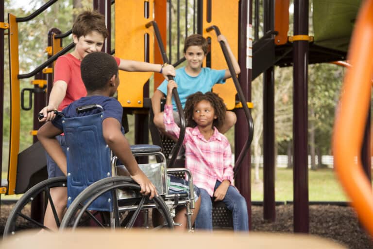 Multi-ethnic group of school children playing on school playground.