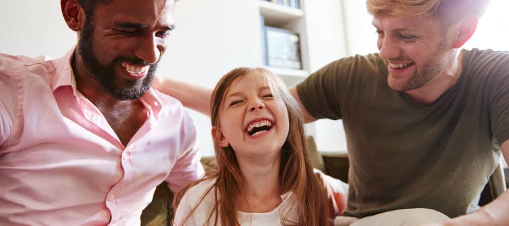 two adults and a child smiling together