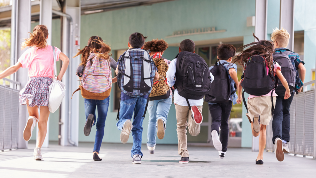 phot of group of children running to school