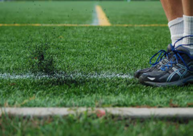 Person's feet, on a turf field