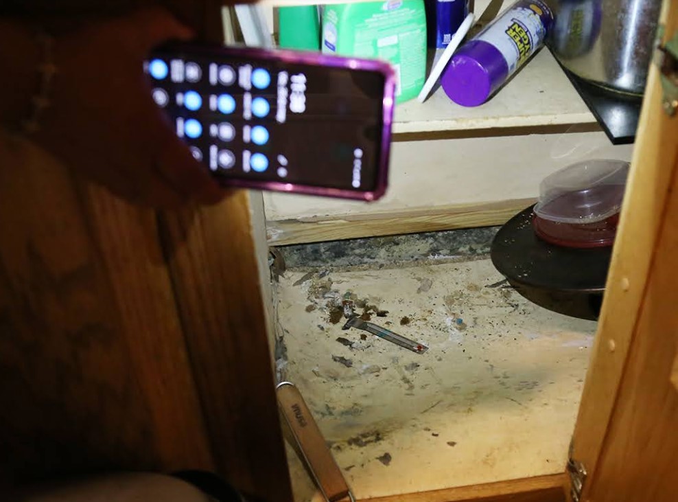 Photo of handheld device lighting up an area below the sink