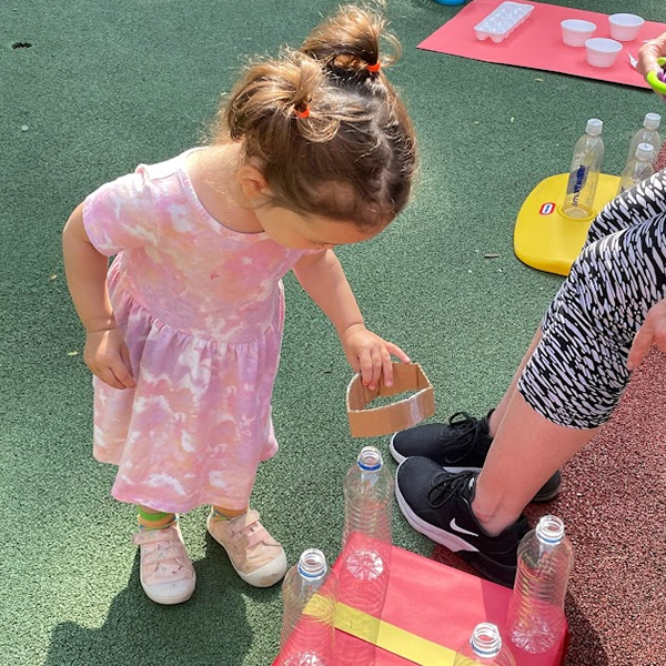 Young girl in a pink dress playing outside