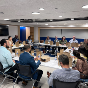 Group of adults sitting around a u-shape set of tables during a professional development session