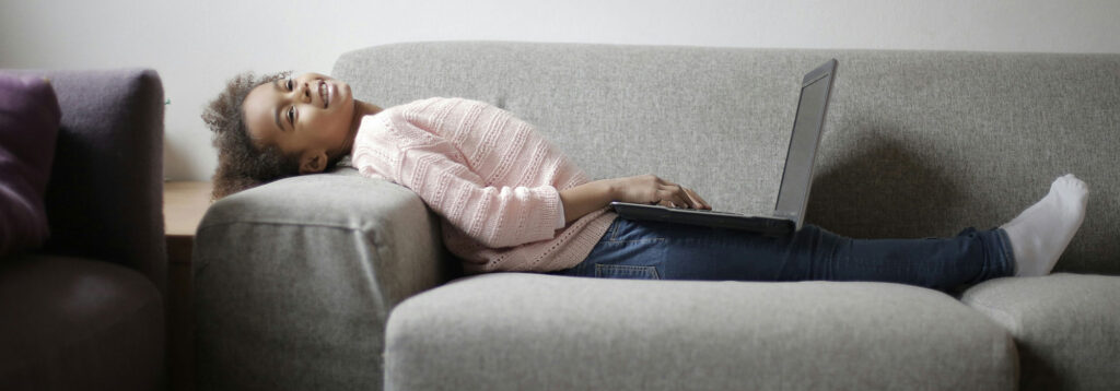 Young girl doing school work on her couch